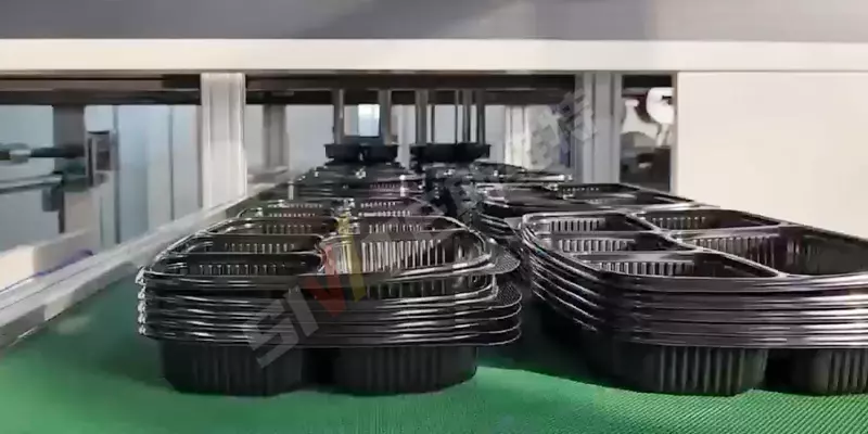 Plastic thermoforming machine stacking station